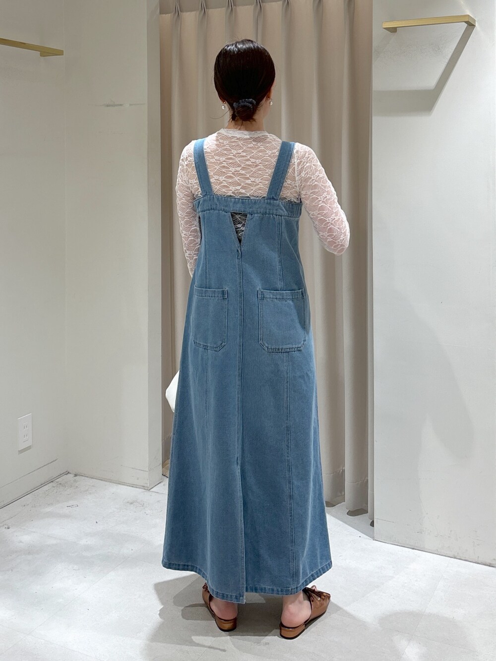 ブルー系のジャンパースカート、ホワイト系のTシャツ/カットソー、ブラウン系のサンダルを着用したレディースの春コーディネートの3枚目の写真