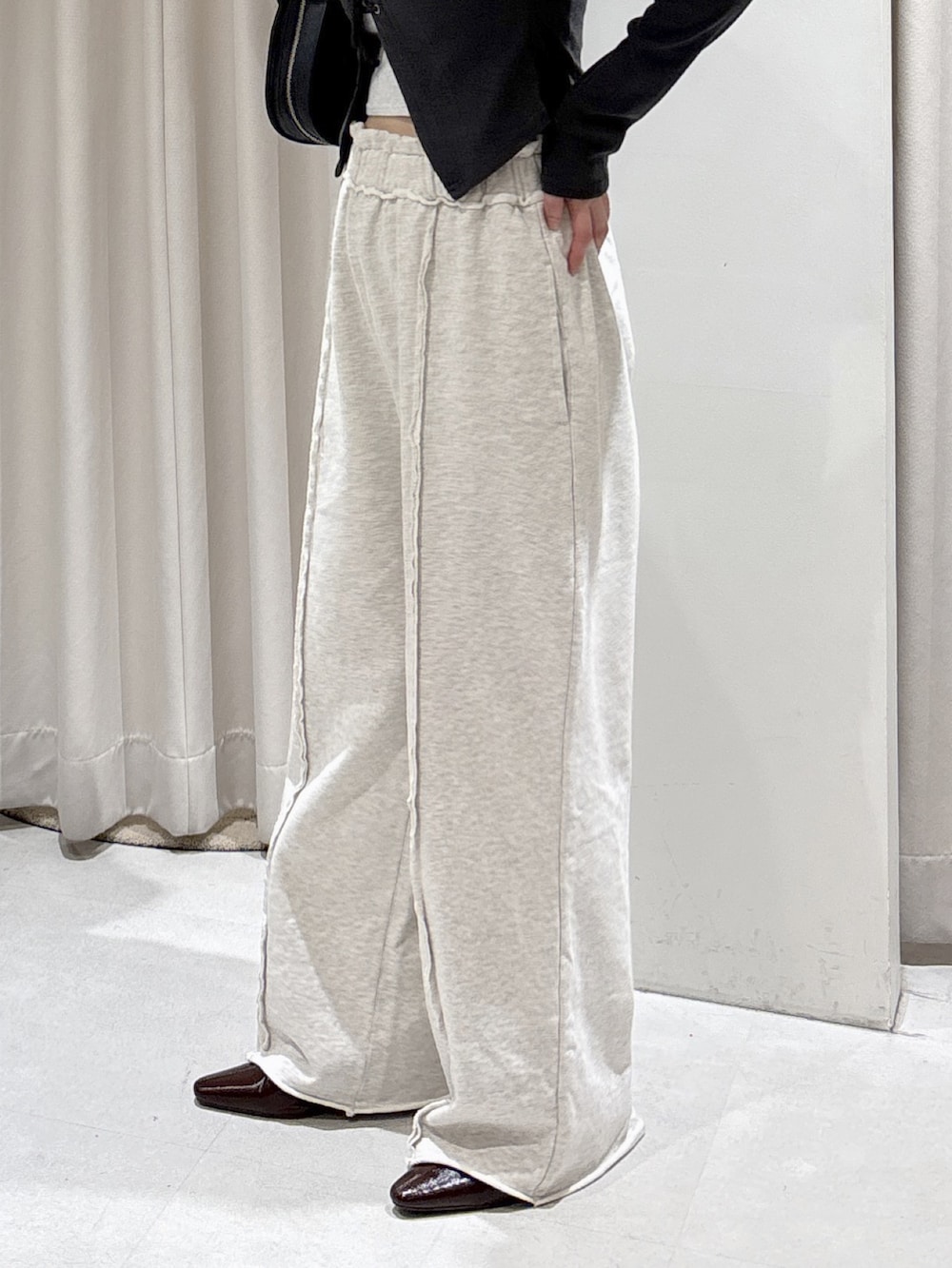 ブラック系のTシャツ/カットソー、ホワイト系のスウェットパンツ、ブラック系のハンドバッグを着用したレディースの秋コーディネートの3枚目の写真