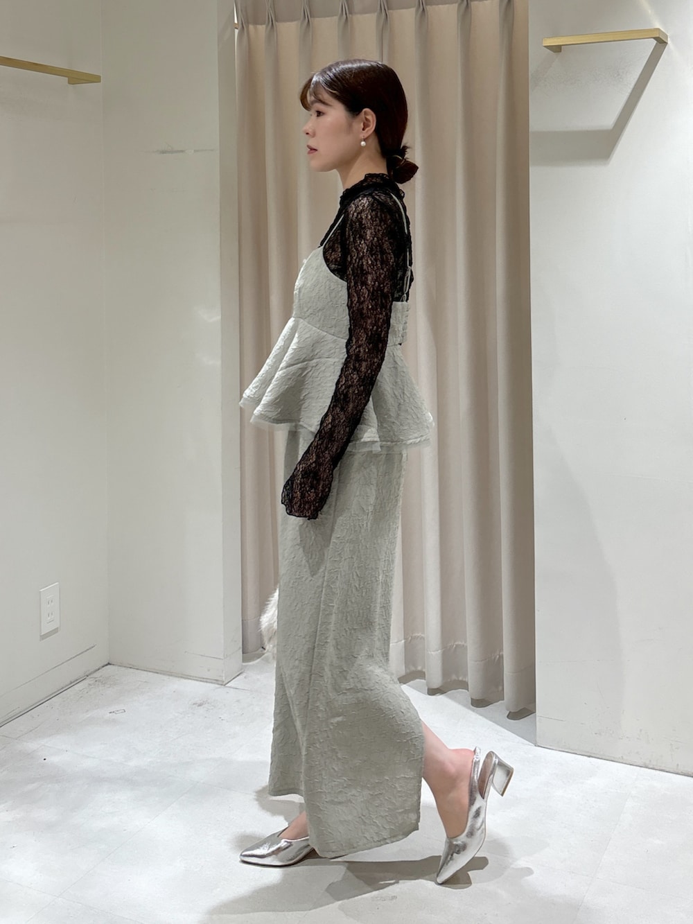 グリーン系のワンピース、ブラック系のTシャツ/カットソー、ベージュ系のショルダーバッグを着用したレディースの冬コーディネートの3枚目の写真