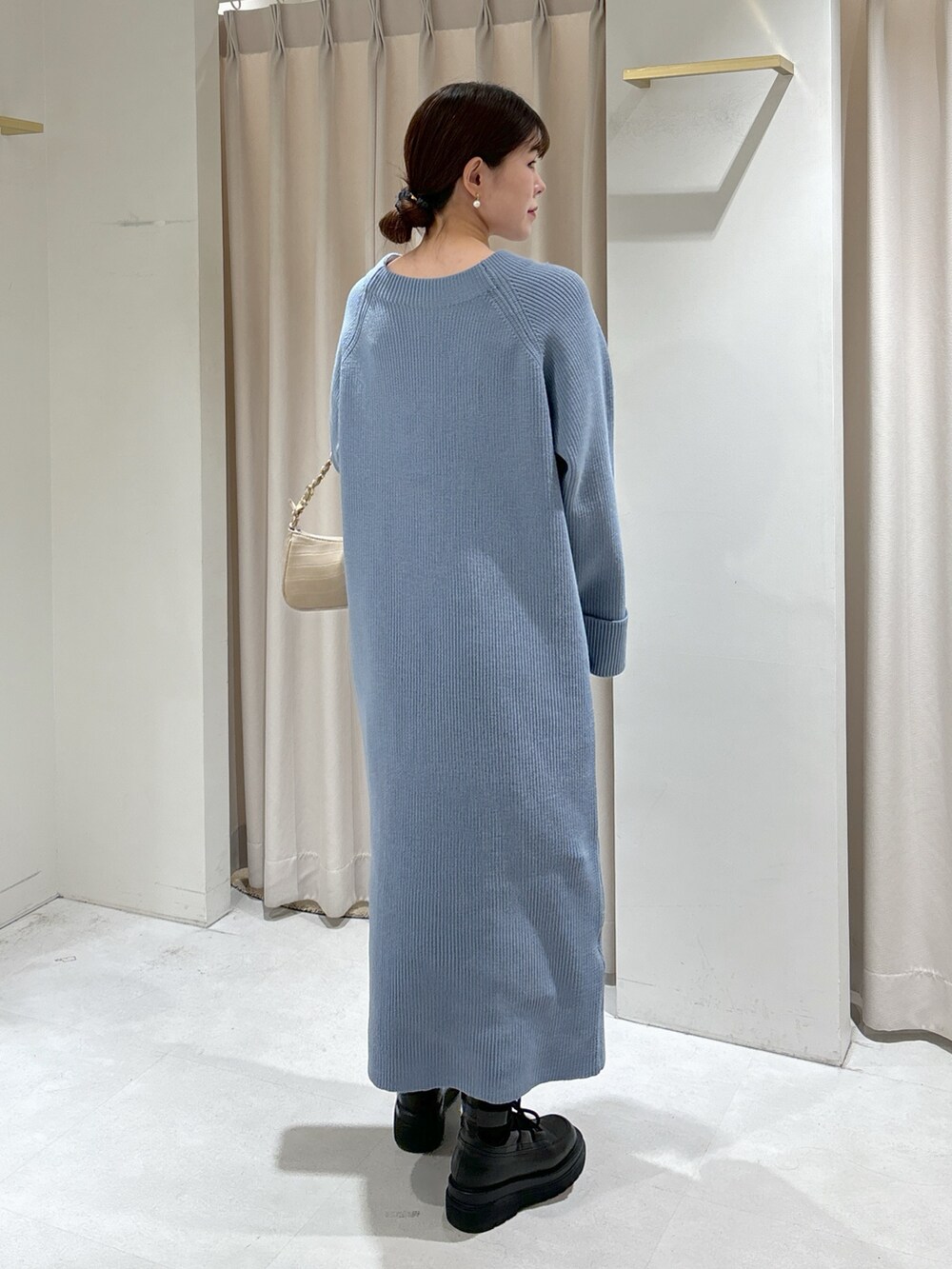 ブルー系のワンピース、ベージュ系のトートバッグ、ブラック系のブーツを着用したレディースの冬コーディネートの5枚目の写真