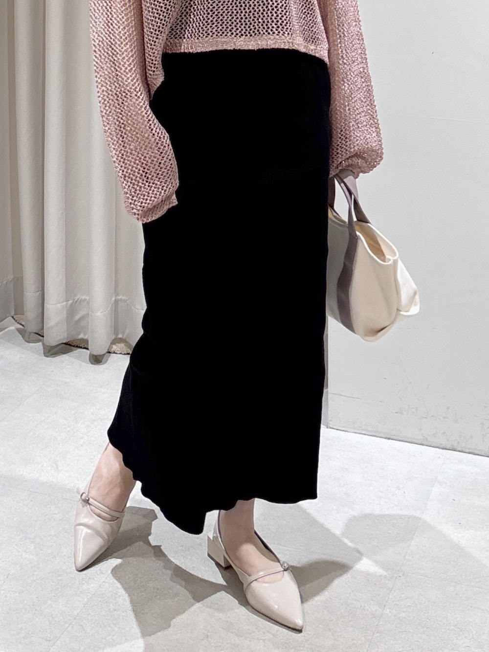 ピンク系のニット/セーター、ブラック系のキャミソール、グレー系のトートバッグを着用したレディースの春コーディネートの7枚目の写真