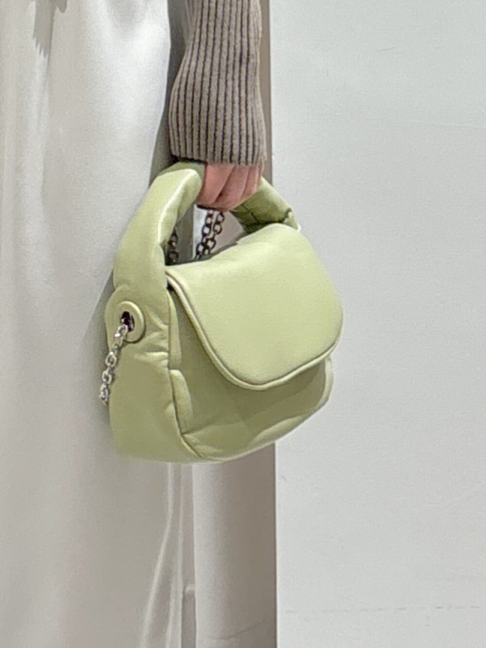 グリーン系のニット/セーター、ブラック系のTシャツ/カットソー、ホワイト系のキャミソールを着用したレディースの冬コーディネートの5枚目の写真