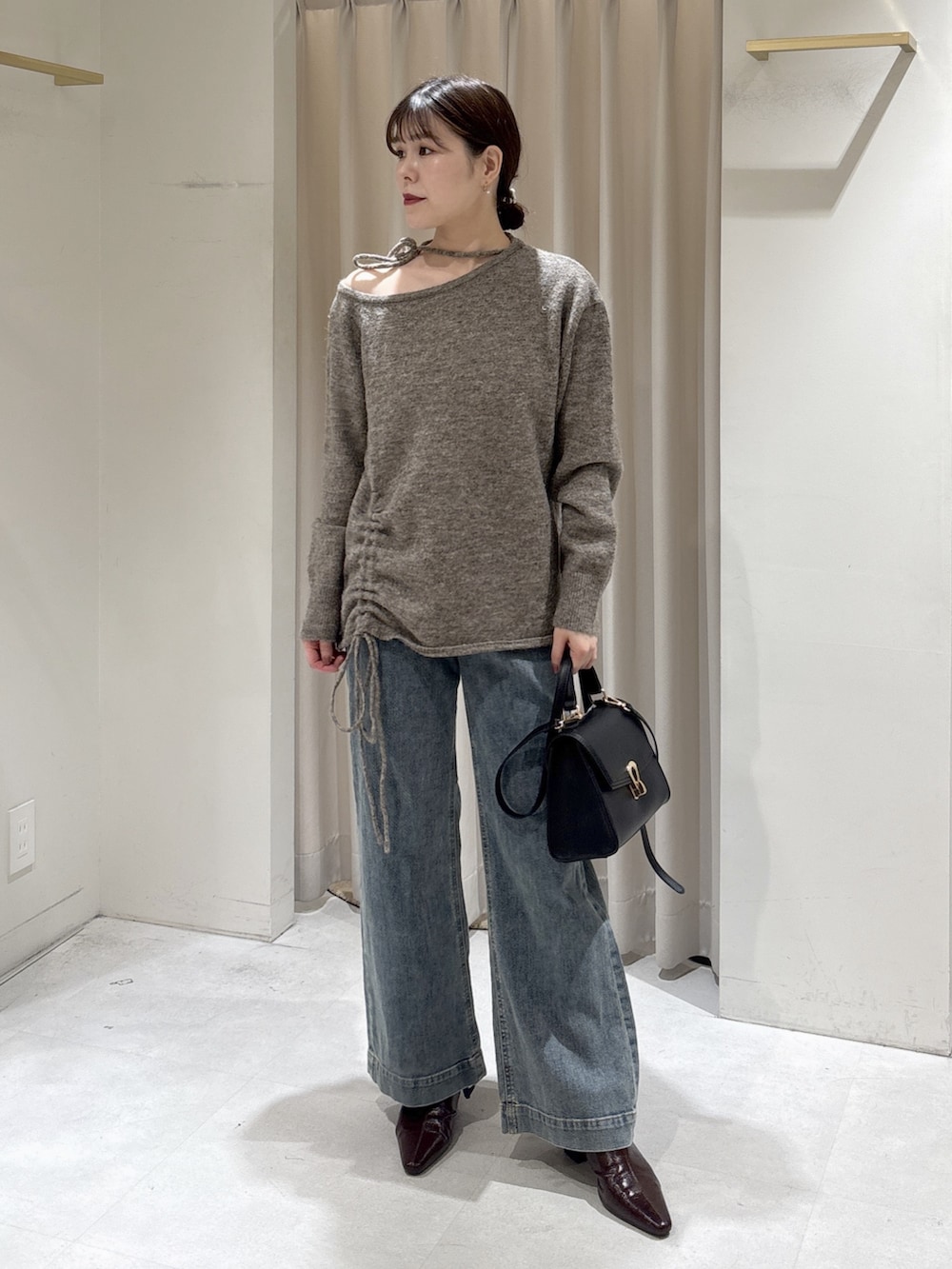 ブラウン系のニット/セーター、ブルー系のデニムパンツ、ブラック系のトートバッグを着用したレディースの冬コーディネートの2枚目の写真