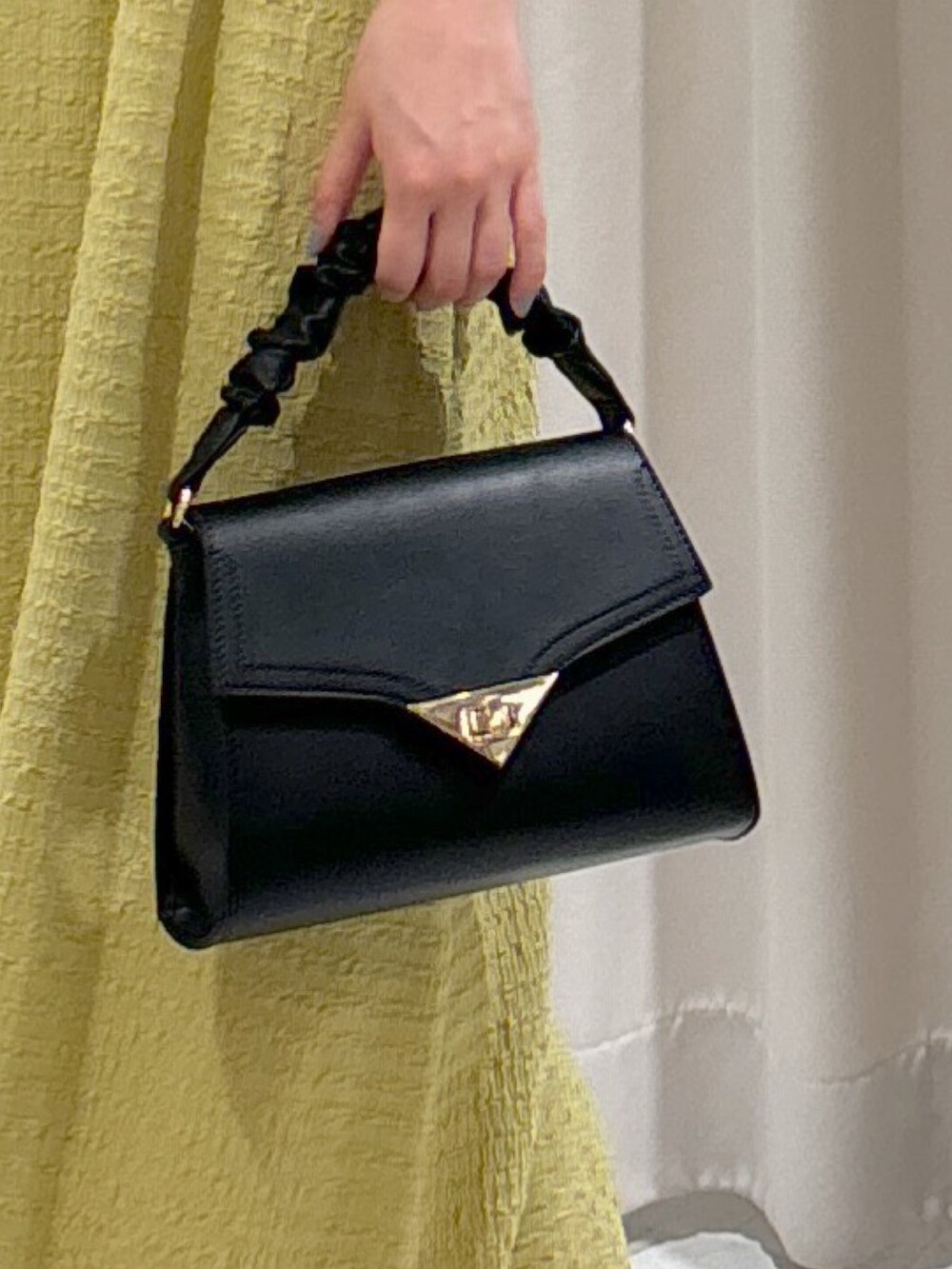 イエロー系のワンピース、ブラック系のショルダーバッグ、グレー系のサンダルを着用したレディースの夏コーディネートの8枚目の写真