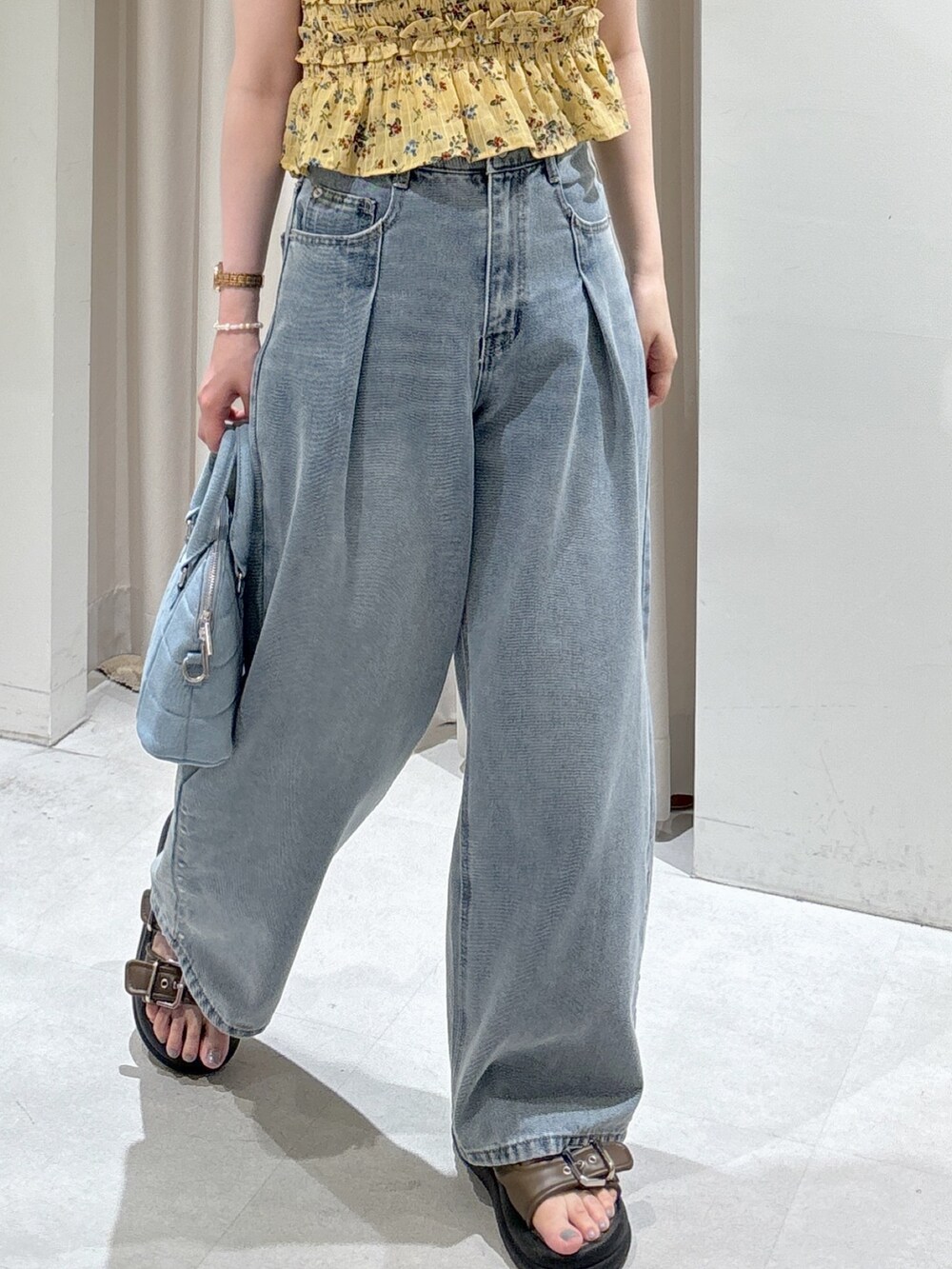 イエロー系のシャツ/ブラウス、ブルー系のトートバッグ、ブルー系のデニムパンツを着用したレディースの夏コーディネートの5枚目の写真