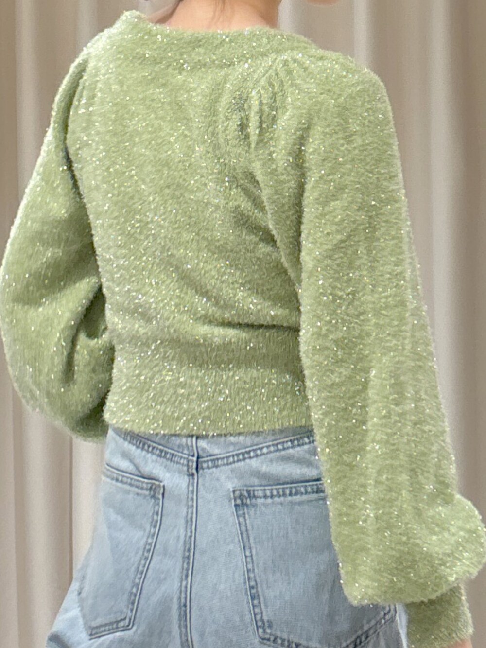 グリーン系のカーディガン/ボレロ、ブルー系のデニムパンツ、ブラック系のハンドバッグを着用したレディースの秋コーディネートの7枚目の写真