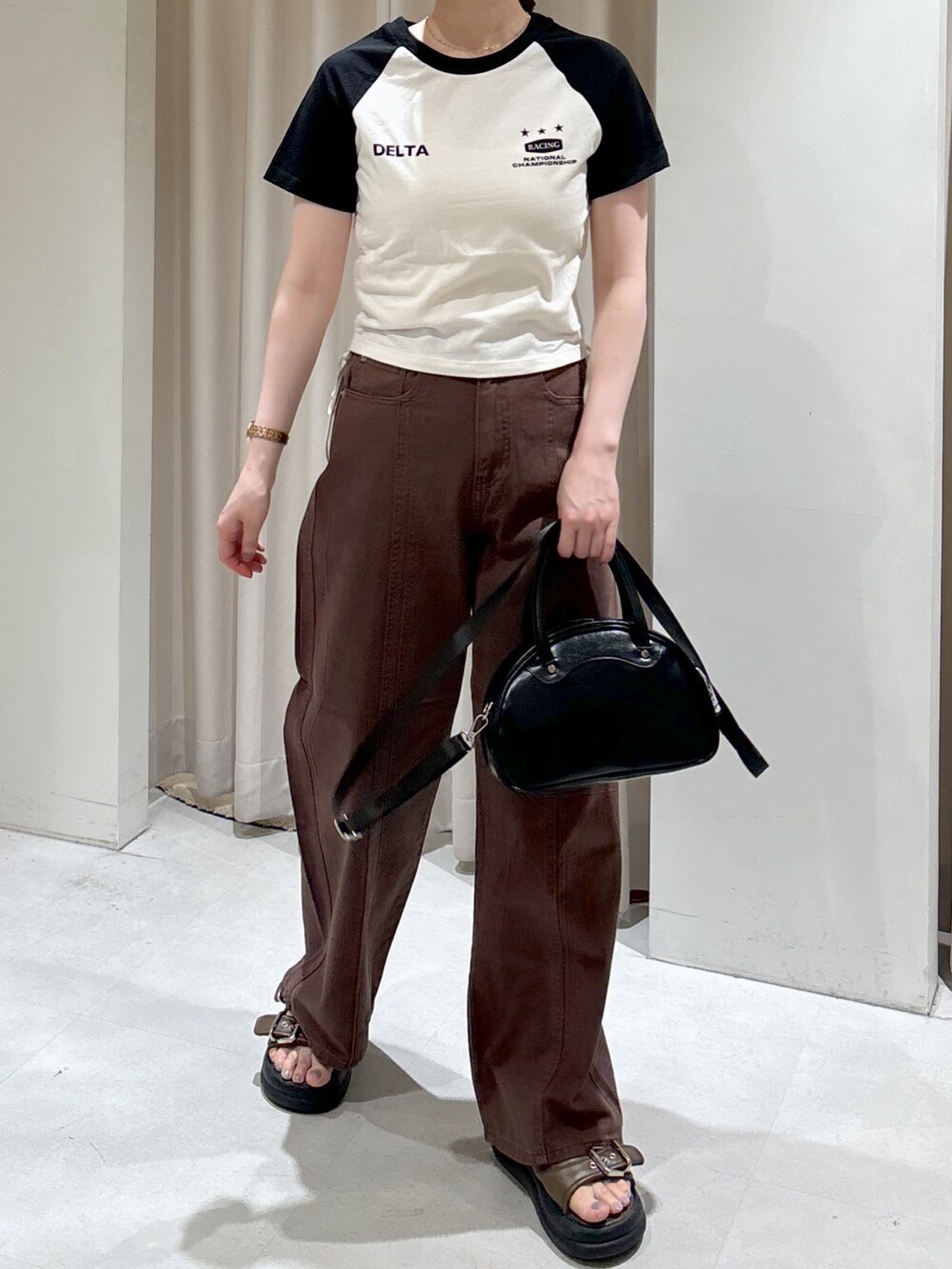 ホワイト系のTシャツ/カットソー、ブラック系のトートバッグ、ブラウン系のサンダルを着用したレディースの夏コーディネートの2枚目の写真