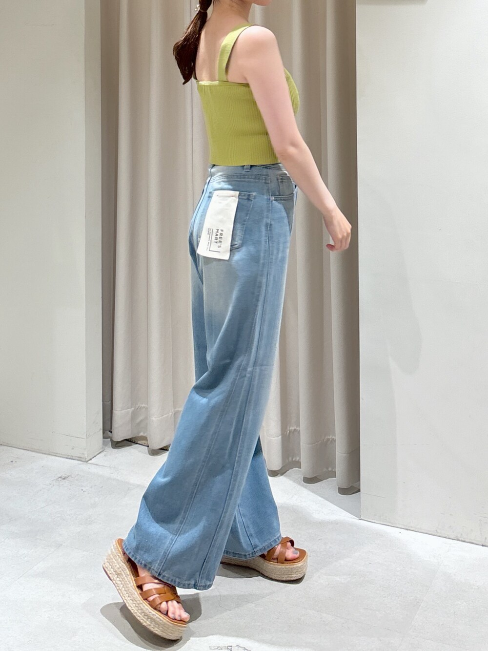 グリーン系のニット/セーター、ブルー系のデニムパンツ、ホワイト系のシャツ/ブラウスを着用したレディースの夏コーディネートの8枚目の写真