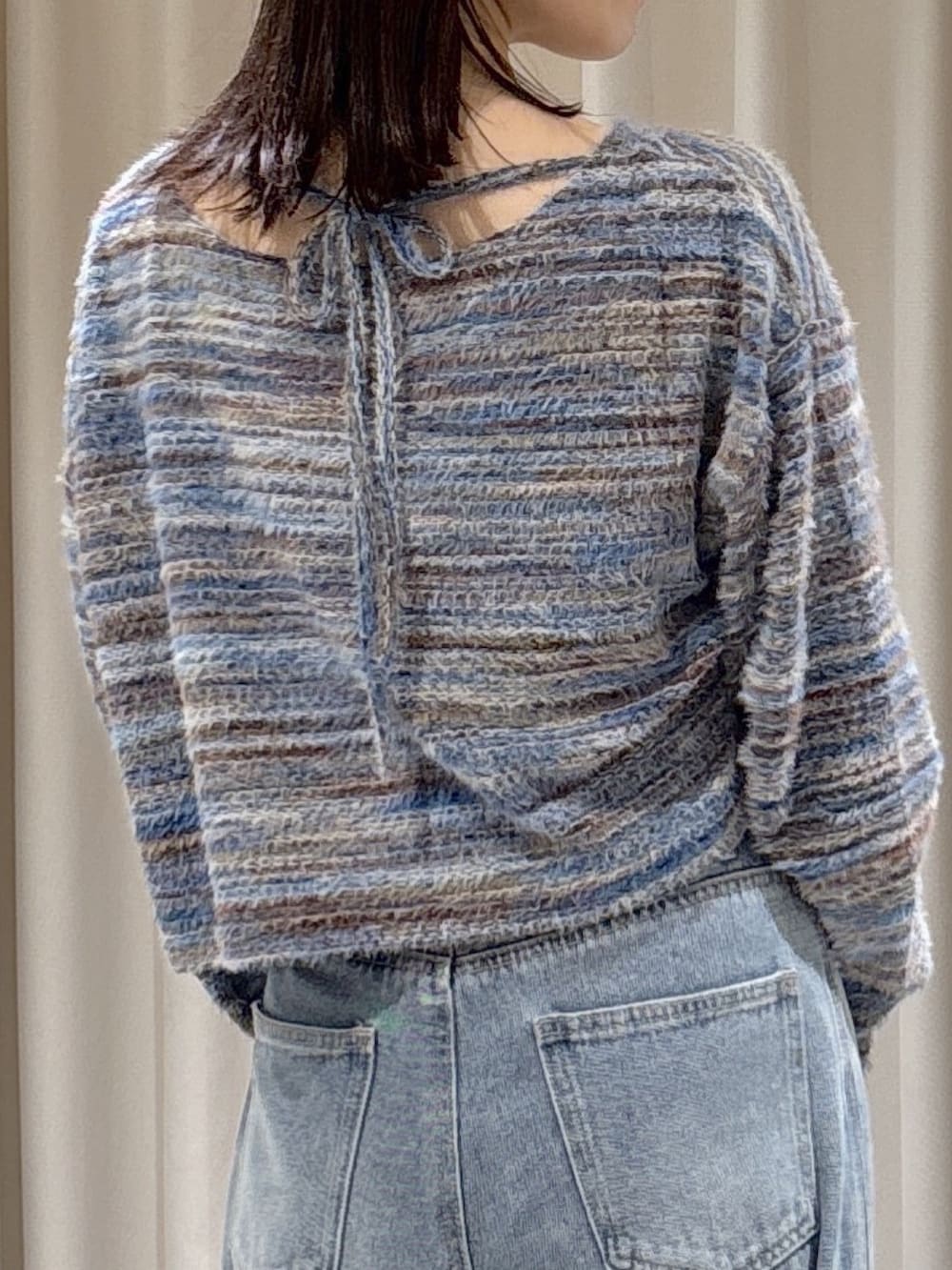 ブラック系のブルゾン、ブルー系のニット/セーター、レッド系のショルダーバッグを着用したレディースの秋コーディネートの9枚目の写真