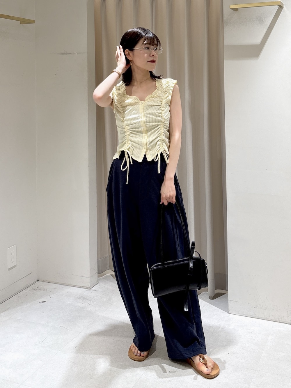 イエロー系のシャツ/ブラウス、ブルー系のその他パンツ、ブラック系のショルダーバッグを着用したレディースの夏コーディネートの4枚目の写真