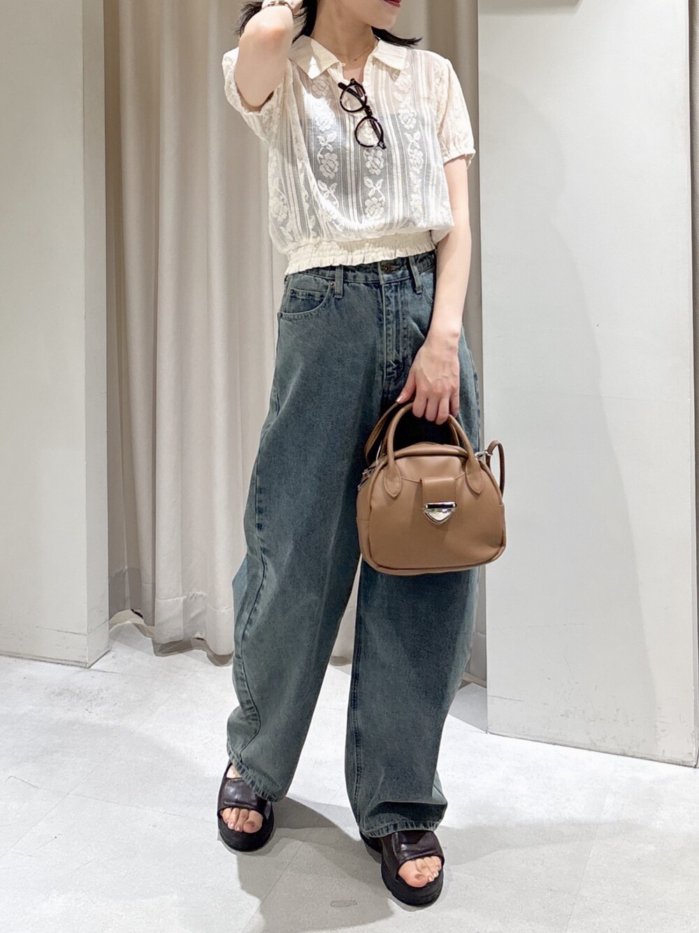 ホワイト系のシャツ/ブラウス、ブラウン系のハンドバッグ、ブルー系のデニムパンツを着用したレディースの夏コーディネートの4枚目の写真