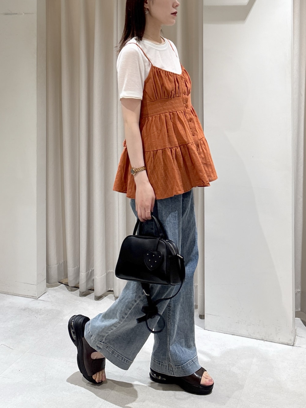 ブラウン系のシャツ/ブラウス、ホワイト系のTシャツ/カットソー、ブラック系のボストンバッグを着用したレディースの春コーディネートの3枚目の写真