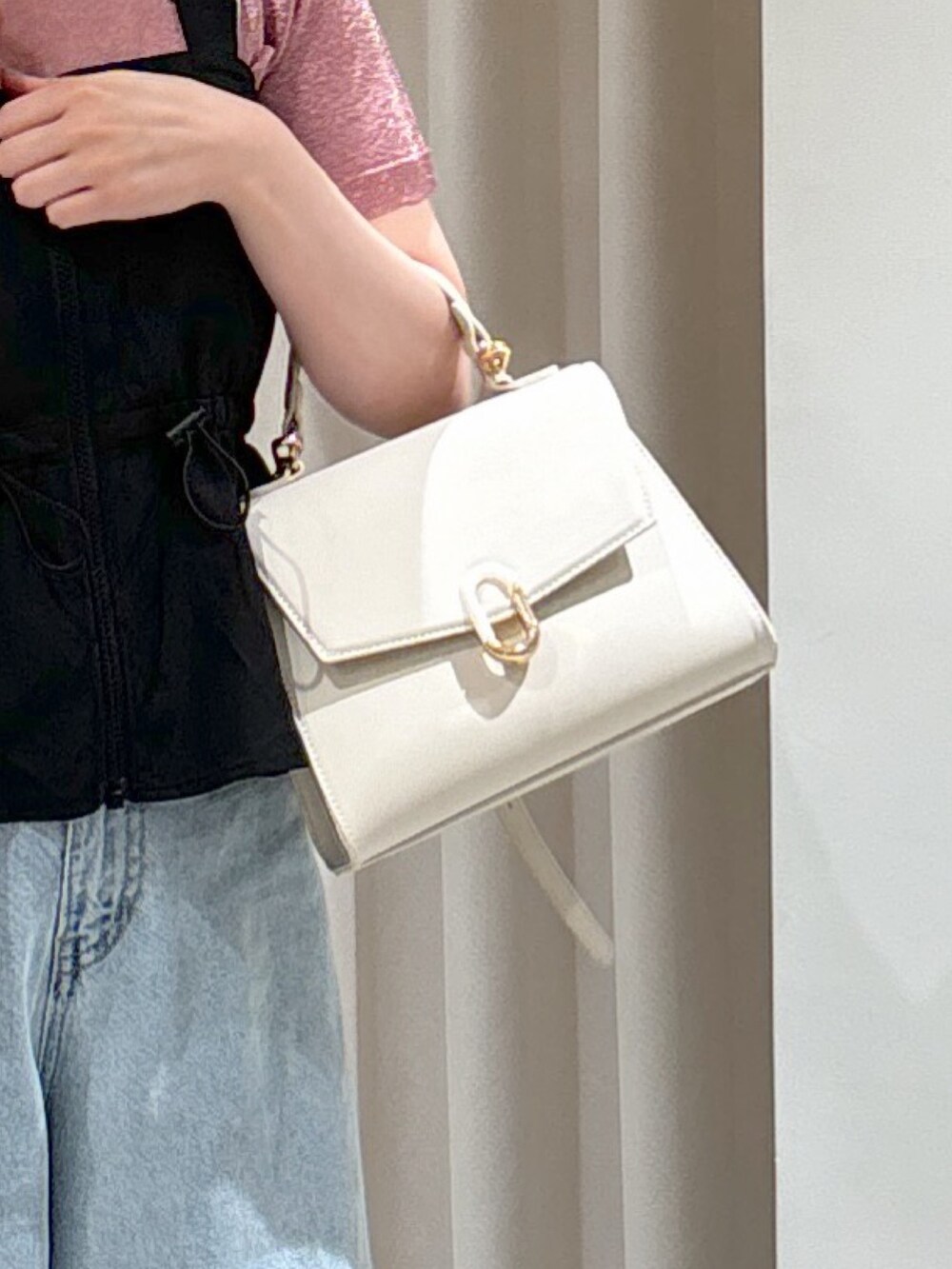 ブラック系のシャツ/ブラウス、ピンク系のニット/セーター、ブルー系のデニムパンツを着用したレディースの夏コーディネートの6枚目の写真