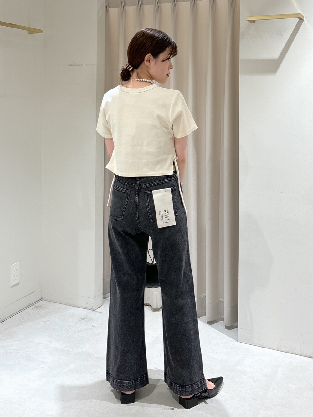 ホワイト系のTシャツ/カットソー、ブラック系のキャミソール、ブラック系のデニムパンツを着用したレディースの秋コーディネートの2枚目の写真