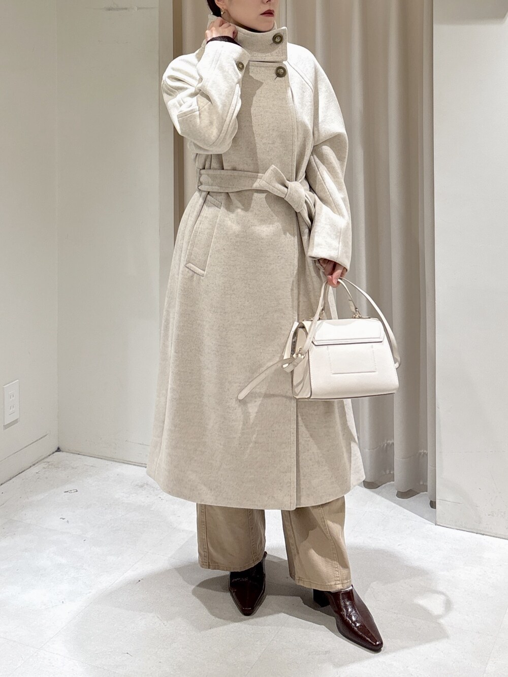 ブラウン系のニット/セーター、ベージュ系のデニムパンツ、ブラウン系のパンプスを着用したレディースの秋コーディネートの7枚目の写真