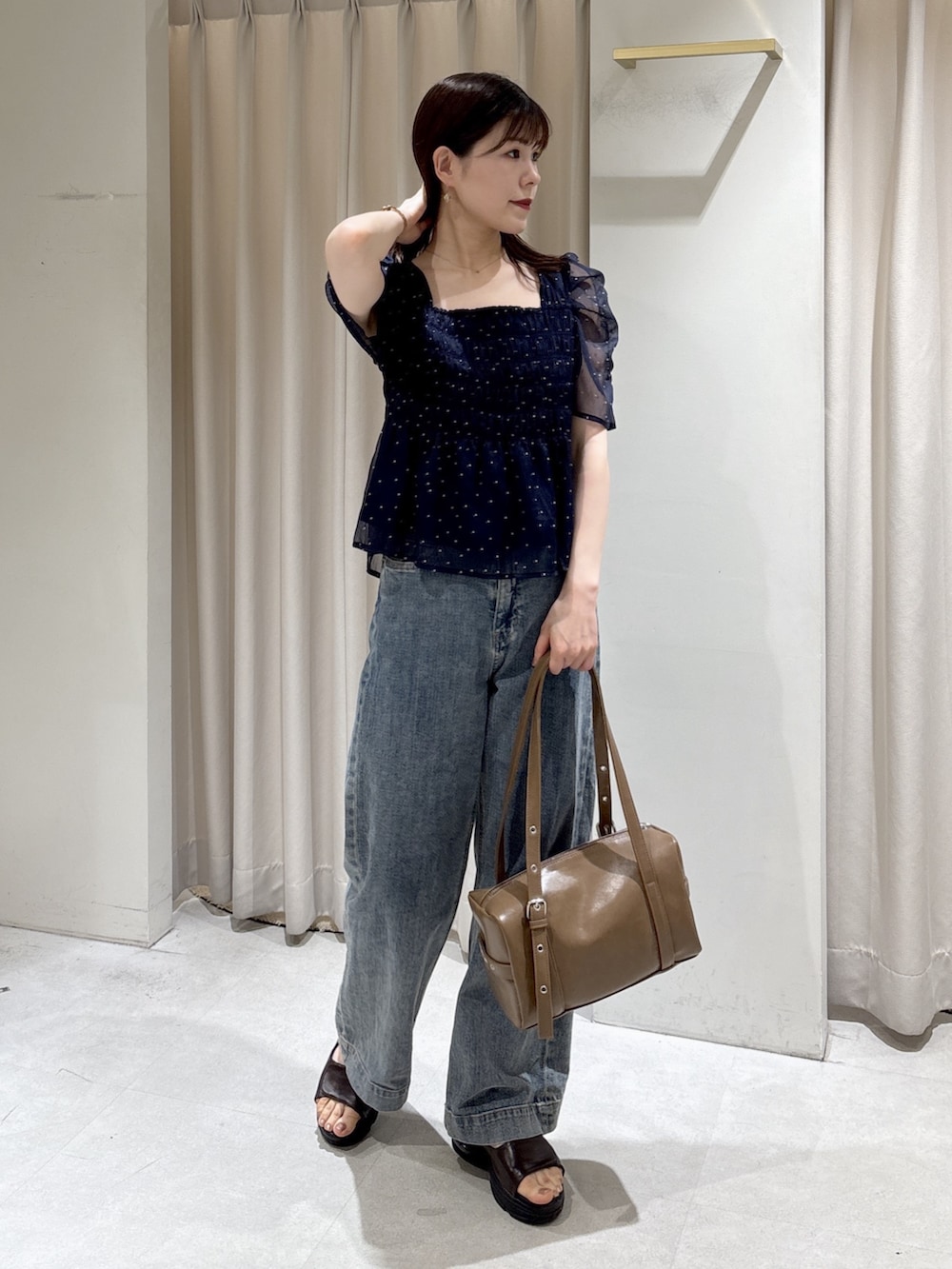 ブルー系のシャツ/ブラウス、ブルー系のデニムパンツ、ブラウン系のショルダーバッグを着用したレディースの夏コーディネートの3枚目の写真