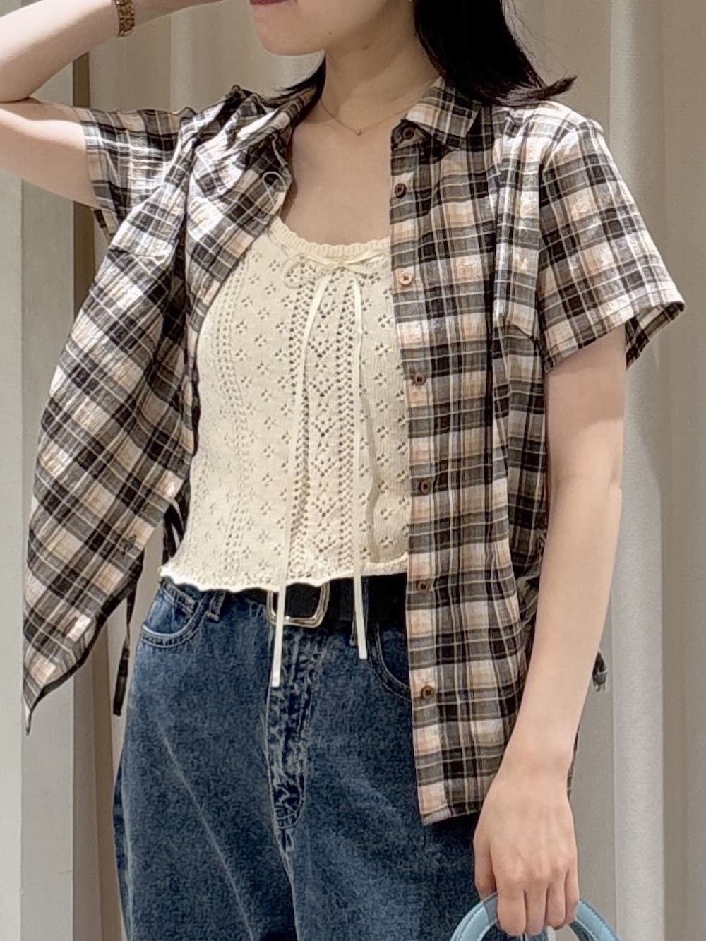 ブラウン系のシャツ/ブラウス、ホワイト系のニット/セーター、ブルー系のショルダーバッグを着用したレディースの夏コーディネートの6枚目の写真