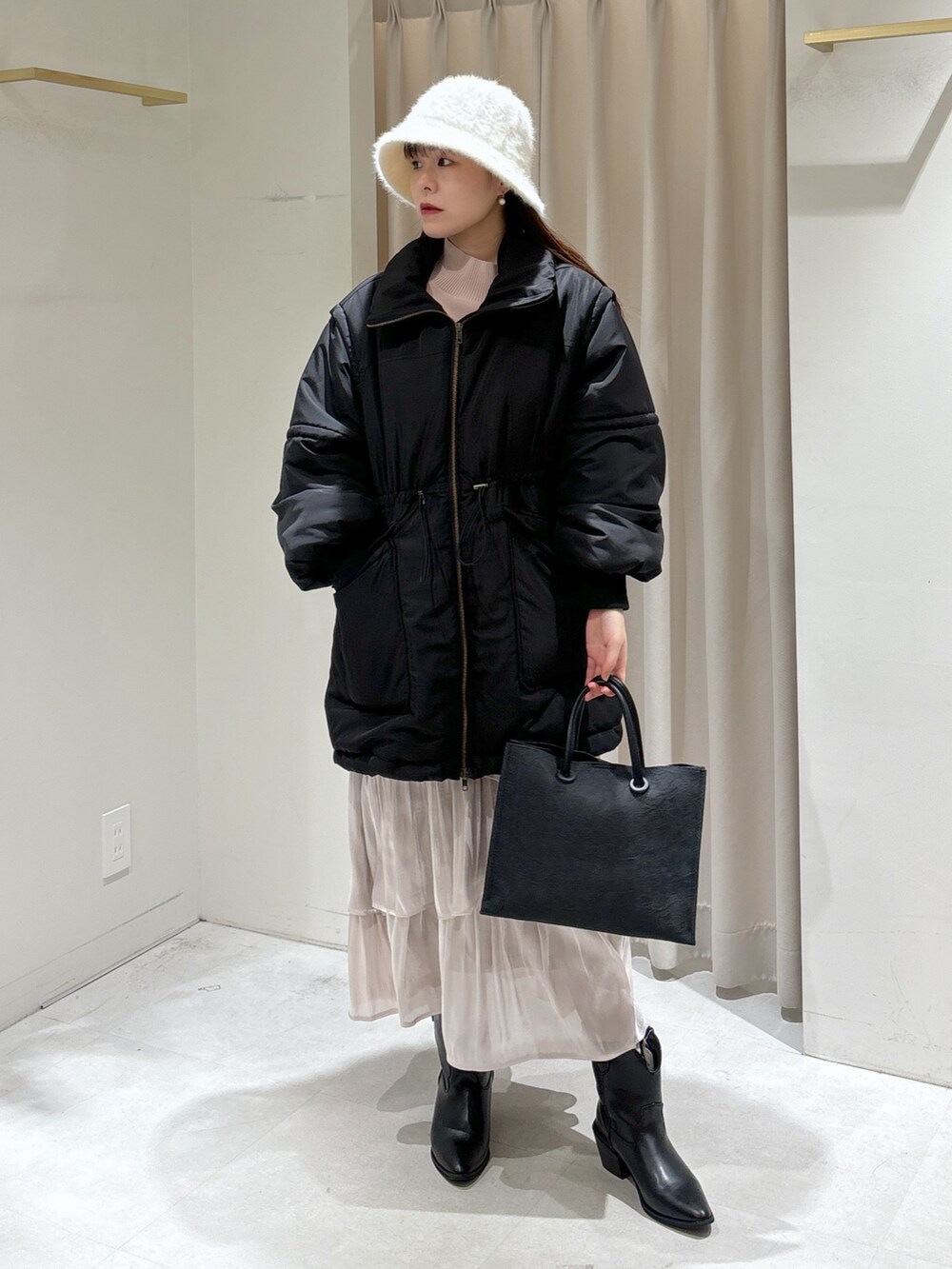 ホワイト系のスカート、ブラック系のその他アウター、ピンク系のニット/セーターを着用したレディースの冬コーディネートの4枚目の写真