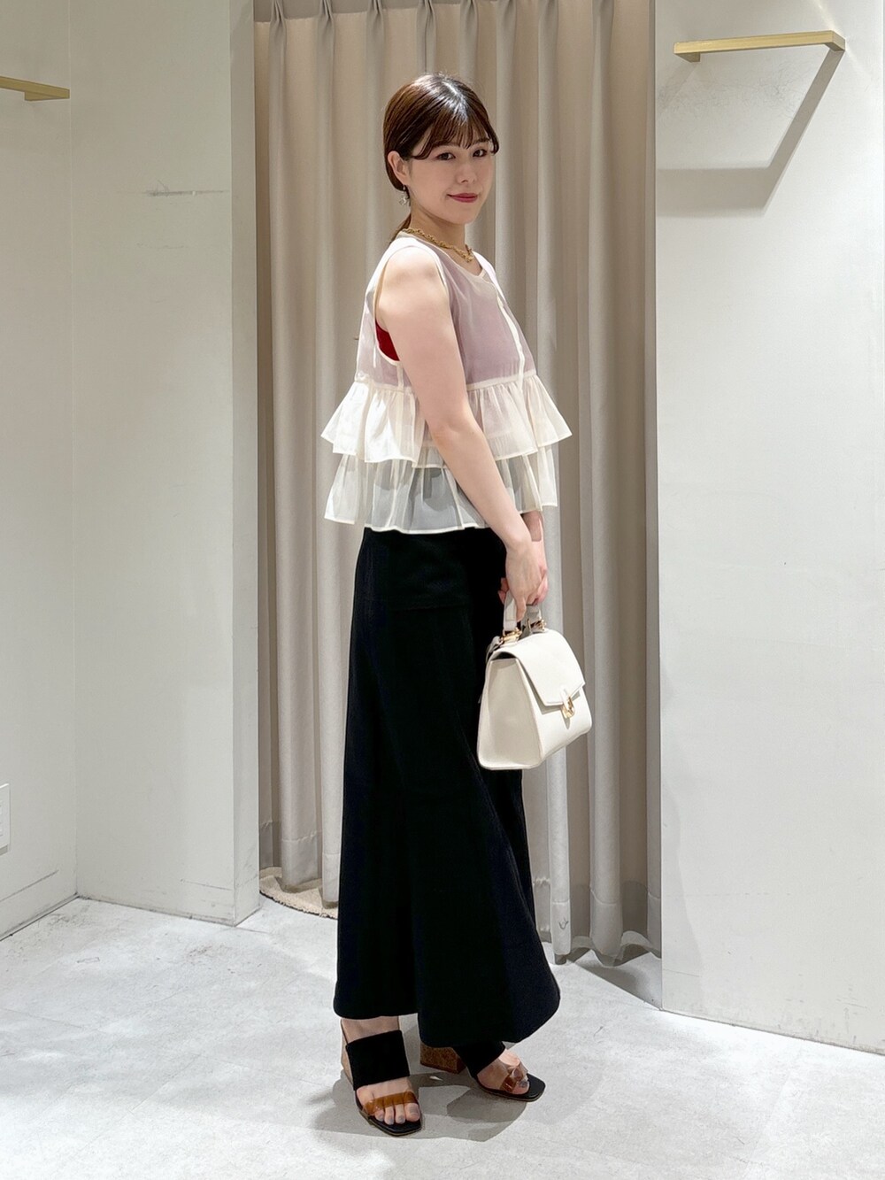 ホワイト系のシャツ/ブラウス、レッド系のタンクトップ、ホワイト系のショルダーバッグを着用したレディースの夏コーディネートの3枚目の写真