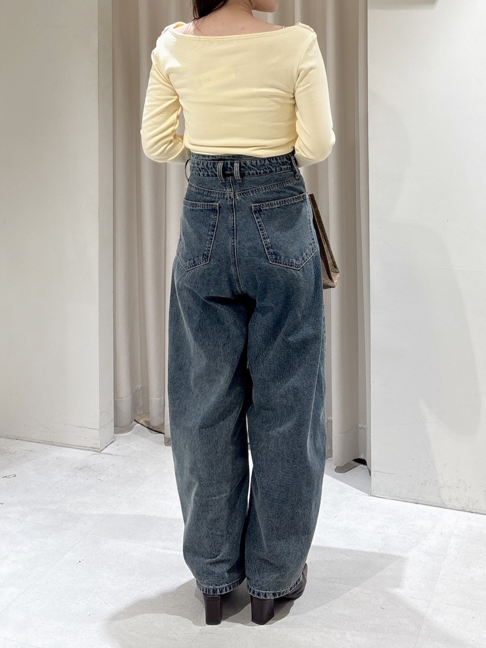 イエロー系のTシャツ/カットソー、ブルー系のデニムパンツ、ブラウン系のパンプスを着用したレディースの冬コーディネートの4枚目の写真