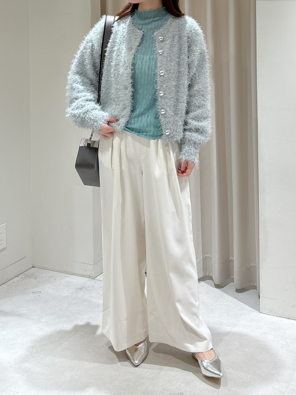 グリーン系のカーディガン/ボレロ、グリーン系のTシャツ/カットソー、ホワイト系のスラックスを着用したレディースの冬コーディネートの4枚目の写真