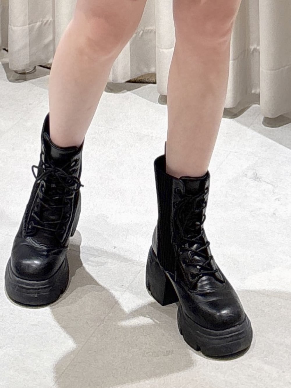 ブラウン系のブルゾン、ブラック系のスカート、ホワイト系のボストンバッグを着用したレディースの冬コーディネートの7枚目の写真