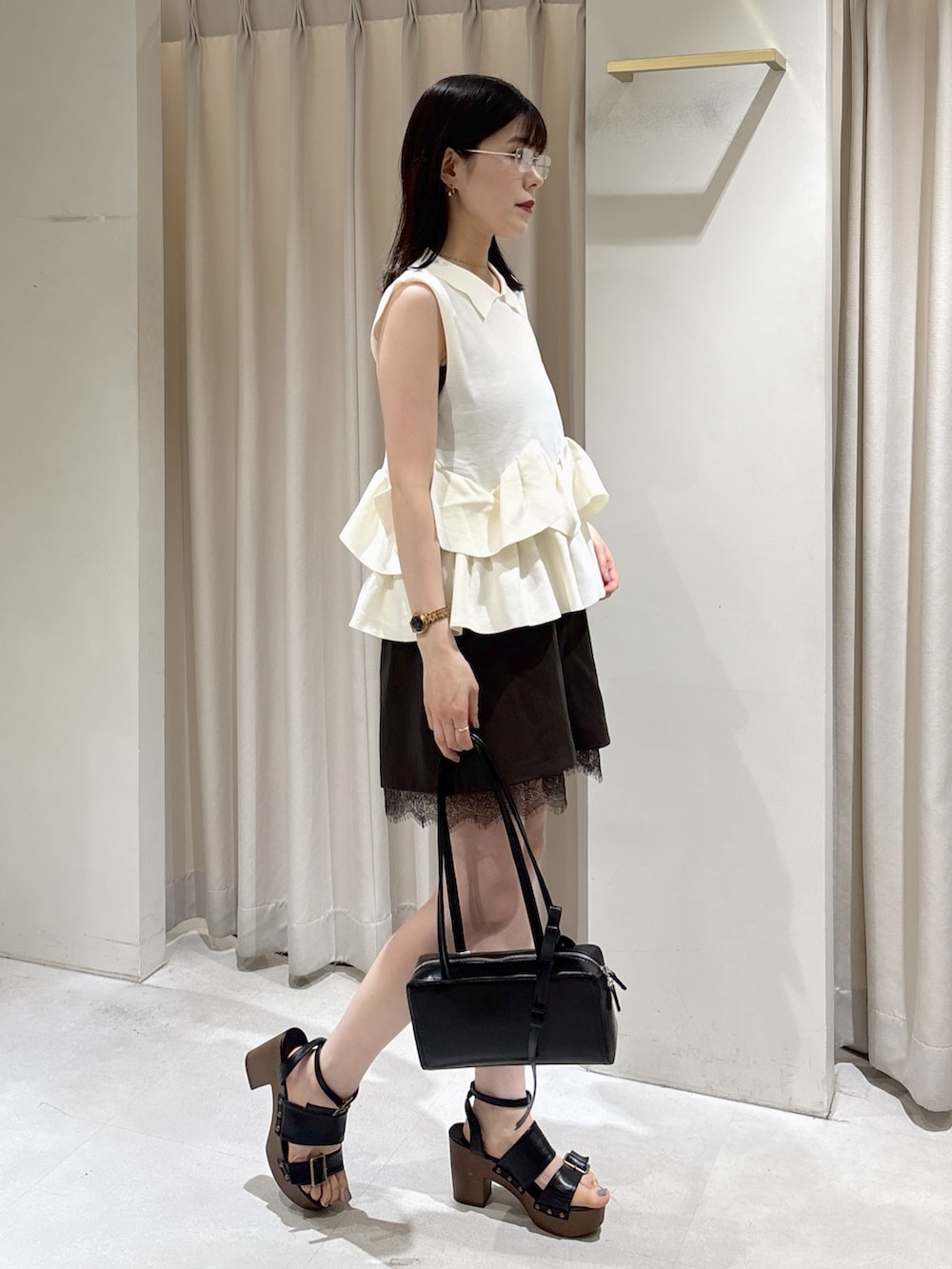 ホワイト系のニット/セーター、ブラウン系のその他パンツ、ブラック系のショルダーバッグを着用したレディースの夏コーディネートの2枚目の写真