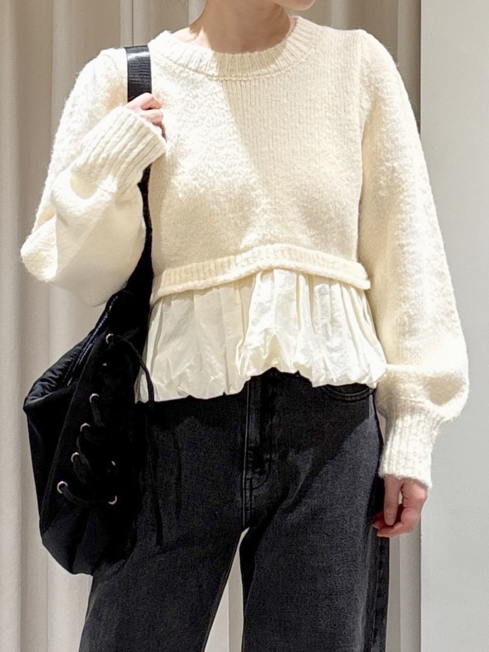 ホワイト系のニット/セーター、ブラック系のトートバッグ、ブラック系のブーツを着用したレディースの秋コーディネートの2枚目の写真