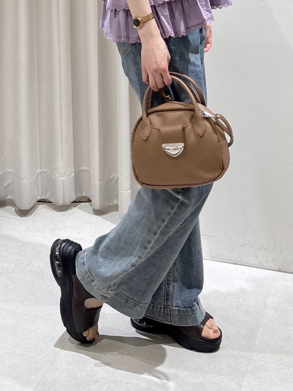 パープル系のシャツ/ブラウス、ブラウン系のハンドバッグ、ブルー系のデニムパンツを着用したレディースの夏コーディネートの5枚目の写真