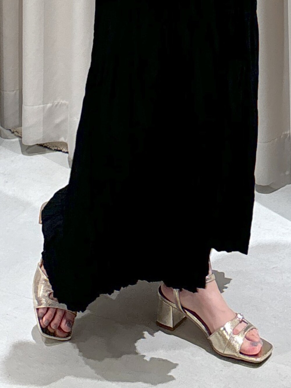 ブラック系のワンピース、ベージュ系のトートバッグ、ゴールド系のサンダルを着用したレディースの夏コーディネートの9枚目の写真