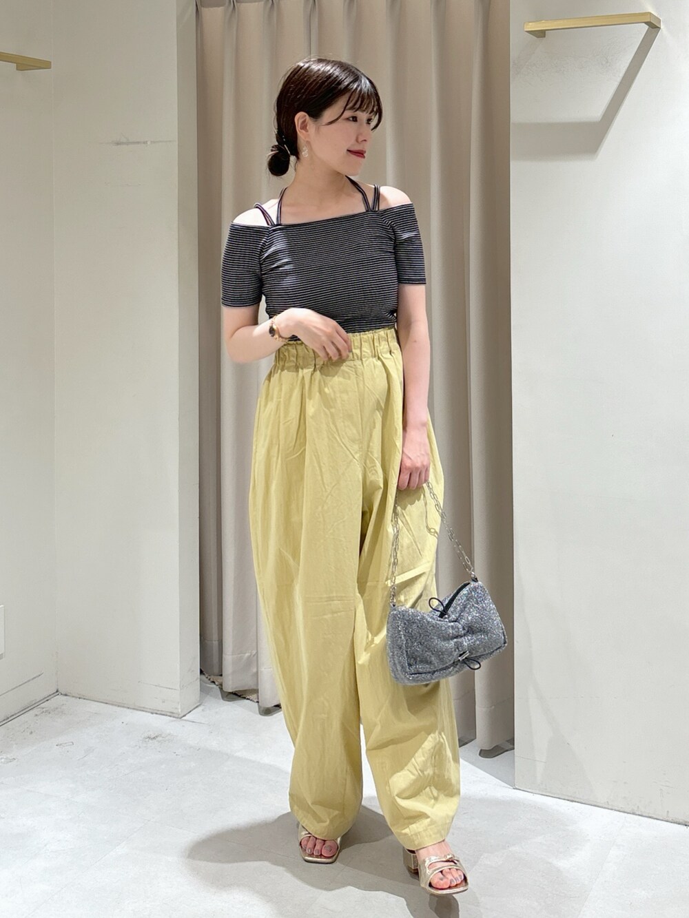 ブラック系のTシャツ/カットソー、イエロー系のその他パンツ、シルバー系のハンドバッグを着用したレディースの夏コーディネートの2枚目の写真