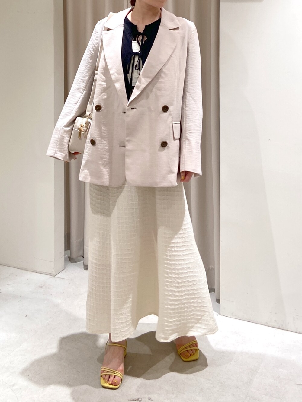 ホワイト系のワンピース、ブラック系のカーディガン/ボレロ、ホワイト系のボディバッグ/ウエストポーチを着用したレディースの春コーディネートの6枚目の写真