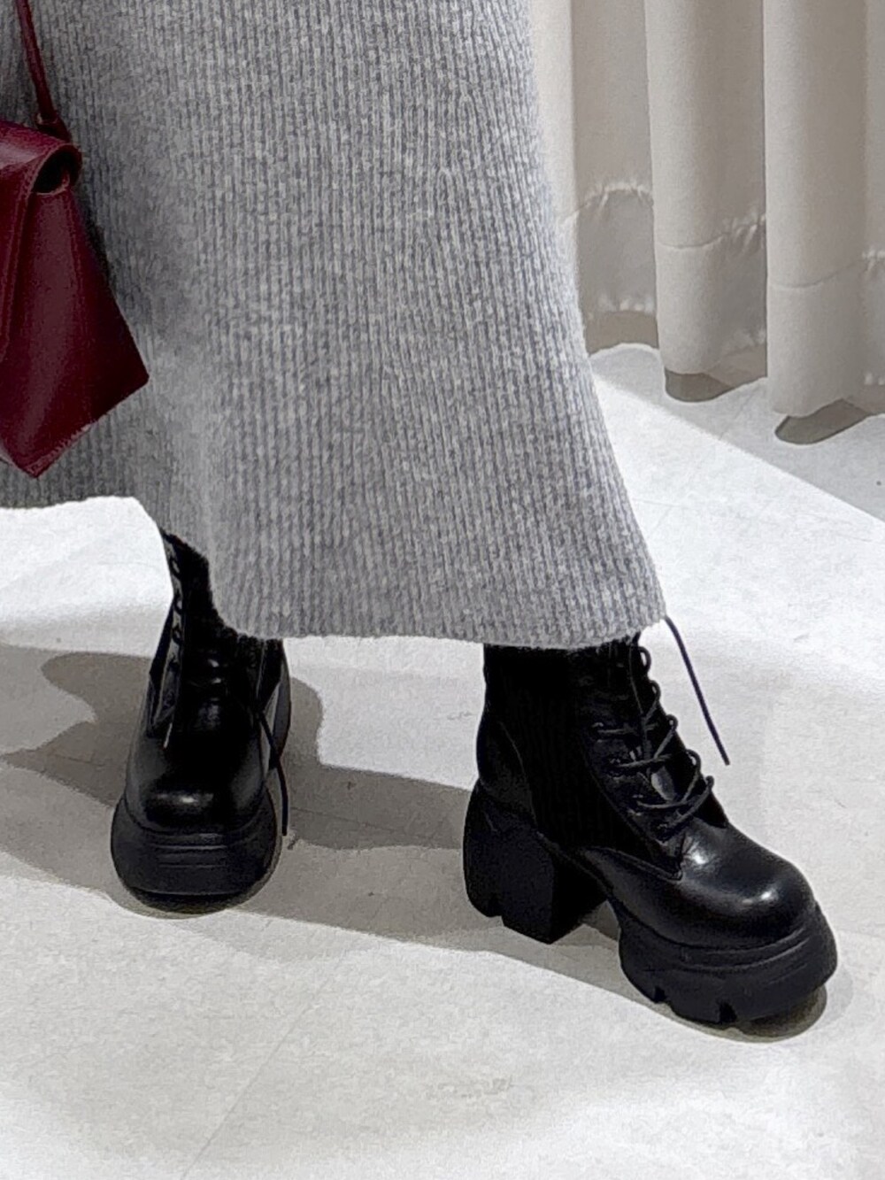 ブルー系のピーコート、レッド系のショルダーバッグ、グレー系のワンピースを着用したレディースの秋コーディネートの8枚目の写真