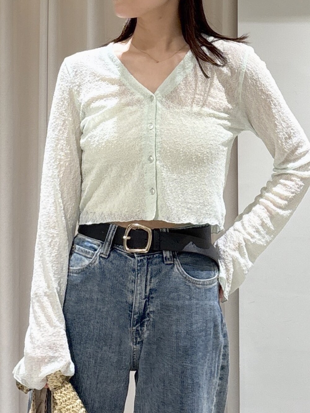 グリーン系のTシャツ/カットソー、ホワイト系のキャミソール、ブルー系のデニムパンツを着用したレディースの夏コーディネートの2枚目の写真
