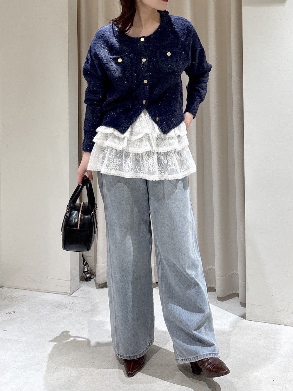 ブルー系のニット/セーター、ホワイト系のシャツ/ブラウス、ブルー系のデニムパンツを着用したレディースの冬コーディネートの5枚目の写真