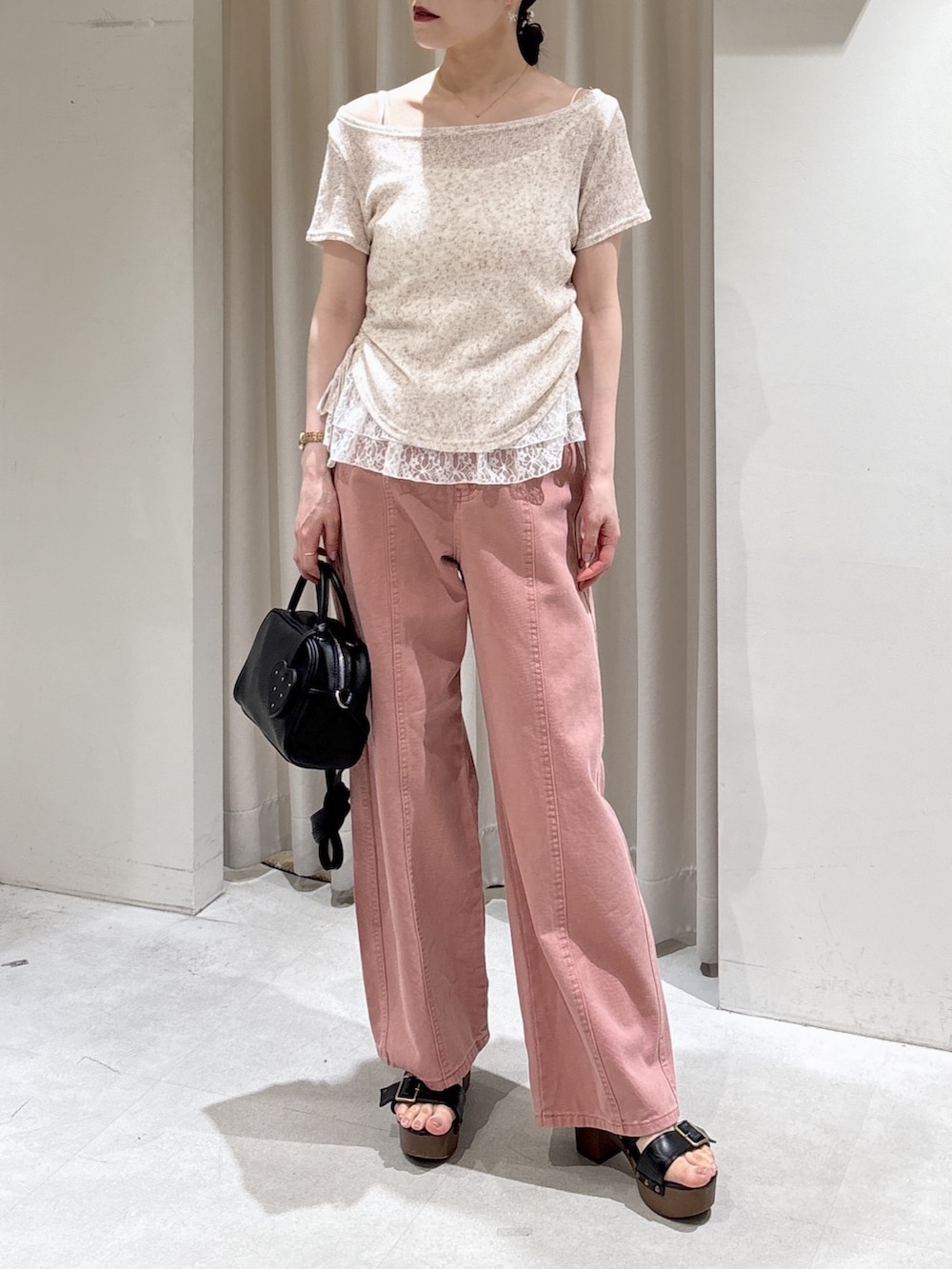 ブラウン系のTシャツ/カットソー、ピンク系のデニムパンツ、ブラック系のボストンバッグを着用したレディースの春コーディネートの2枚目の写真