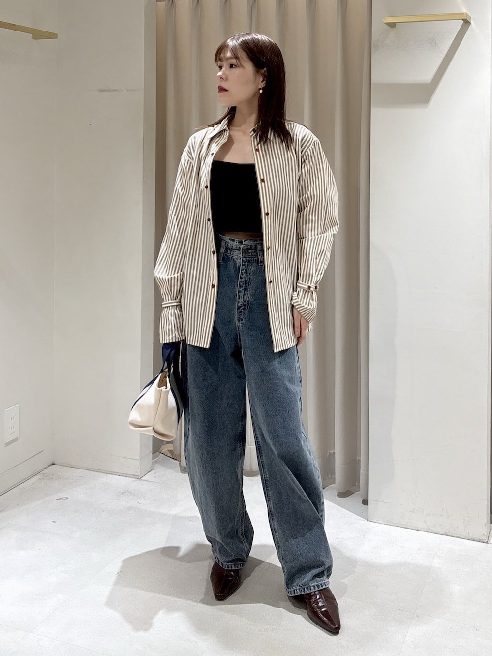 ブラック系のシャツ/ブラウス、ブラウン系のシャツ/ブラウス、ベージュ系のハンドバッグを着用したレディースの冬コーディネートの10枚目の写真