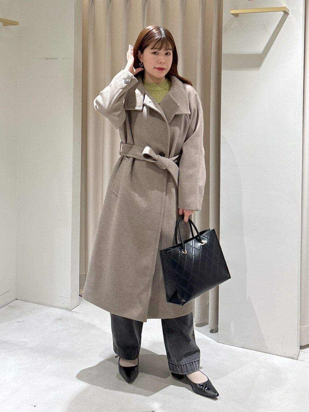 ブラウン系のステンカラーコート、ブラック系のショルダーバッグ、ブラック系のパンプスを着用したレディースの秋コーディネートの5枚目の写真
