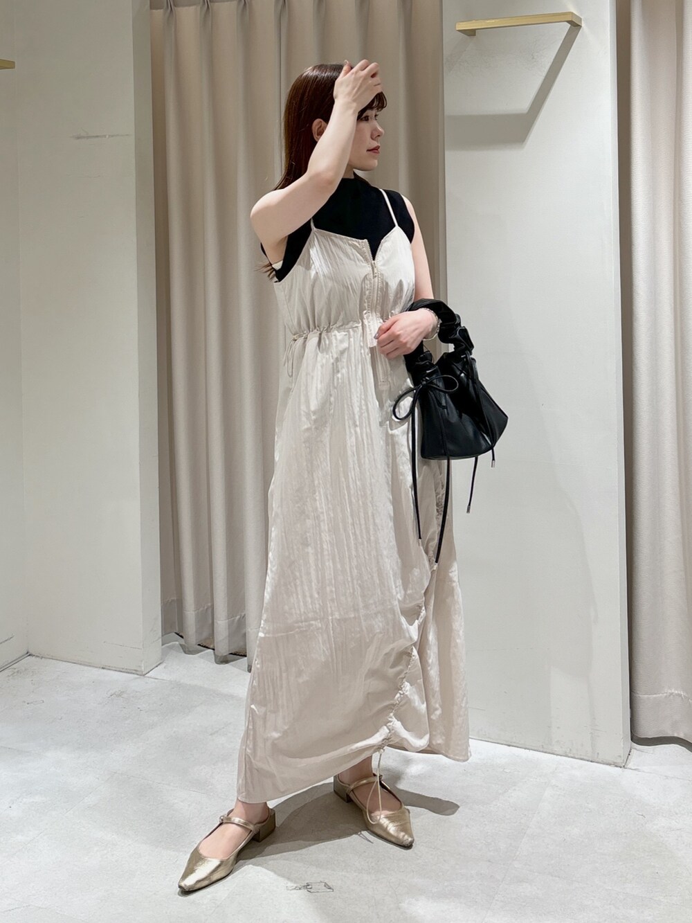 ホワイト系のワンピース、ブラック系のショルダーバッグ、ブラック系のニット/セーターを着用したレディースの春コーディネートの5枚目の写真