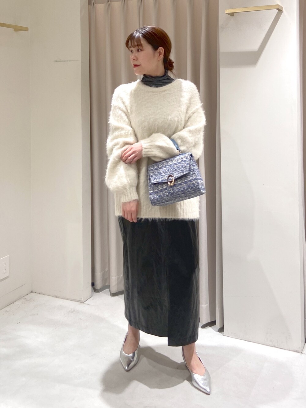 ホワイト系のニット/セーター、ブラック系のTシャツ/カットソー、ブルー系のショルダーバッグを着用したレディースの冬コーディネートの6枚目の写真