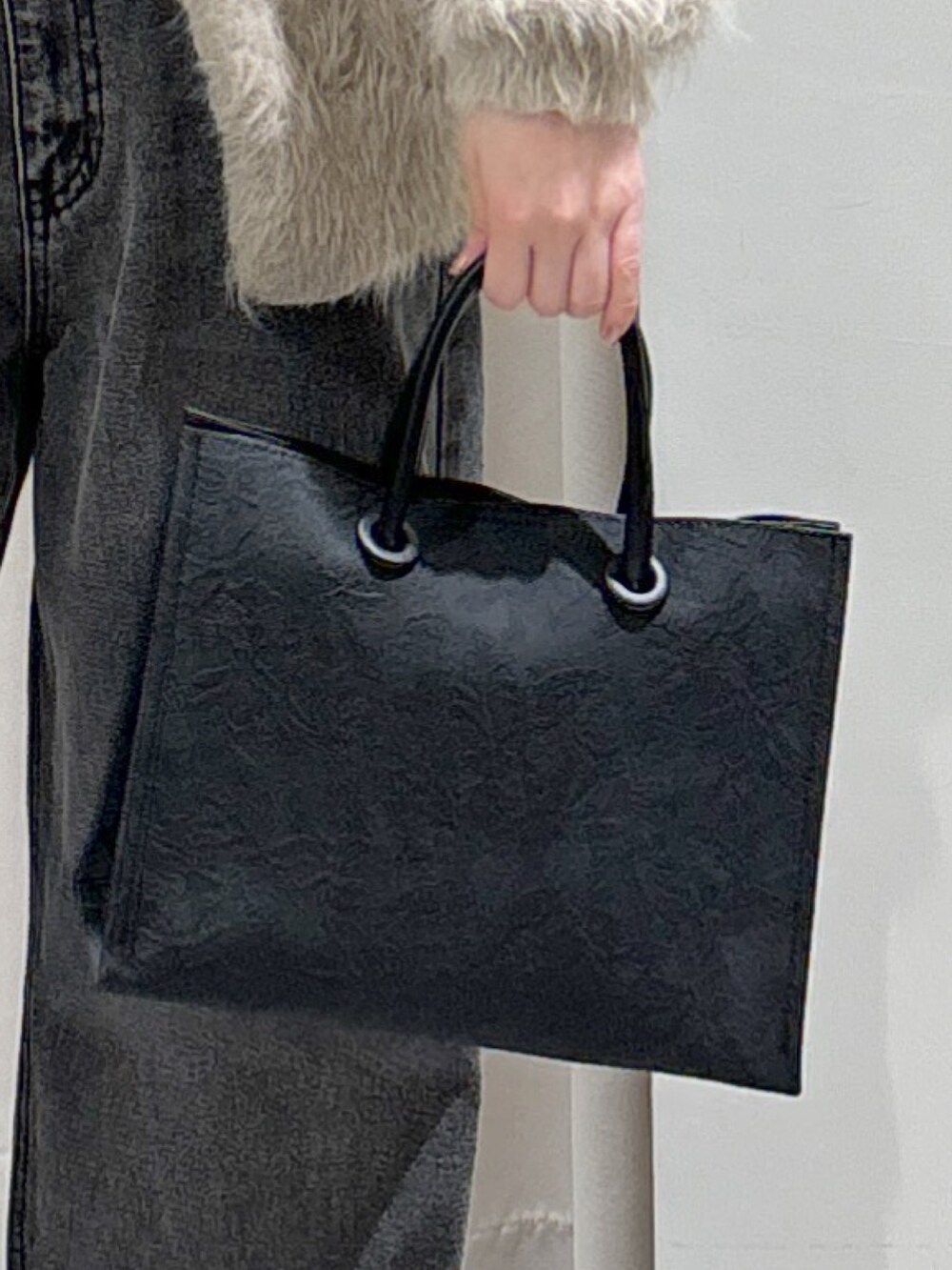 ベージュ系のカーディガン/ボレロ、ブラック系のデニムパンツ、ブラック系のトートバッグを着用したレディースの冬コーディネートの6枚目の写真