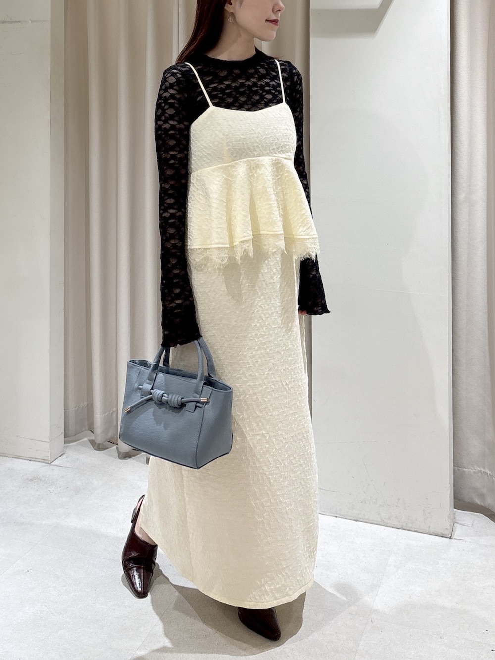 ホワイト系のワンピース、ブラック系のTシャツ/カットソー、ブルー系のハンドバッグを着用したレディースの冬コーディネートの5枚目の写真