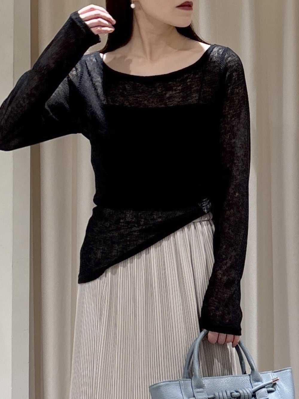 ブラック系のTシャツ/カットソー、ブラック系のキャミソール、ブルー系のハンドバッグを着用したレディースの冬コーディネートの3枚目の写真