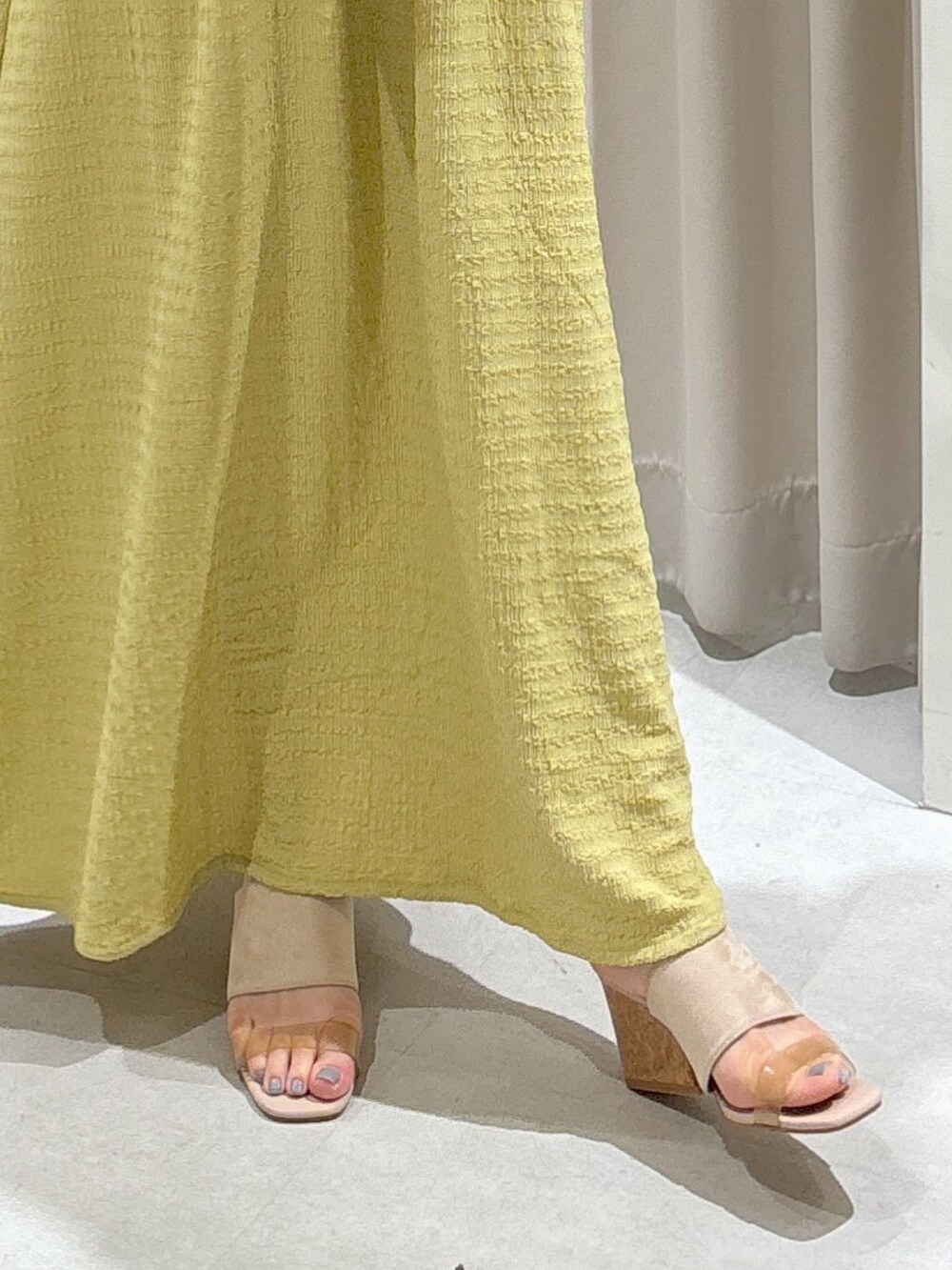 イエロー系のワンピース、ブラック系のショルダーバッグ、グレー系のサンダルを着用したレディースの夏コーディネートの9枚目の写真