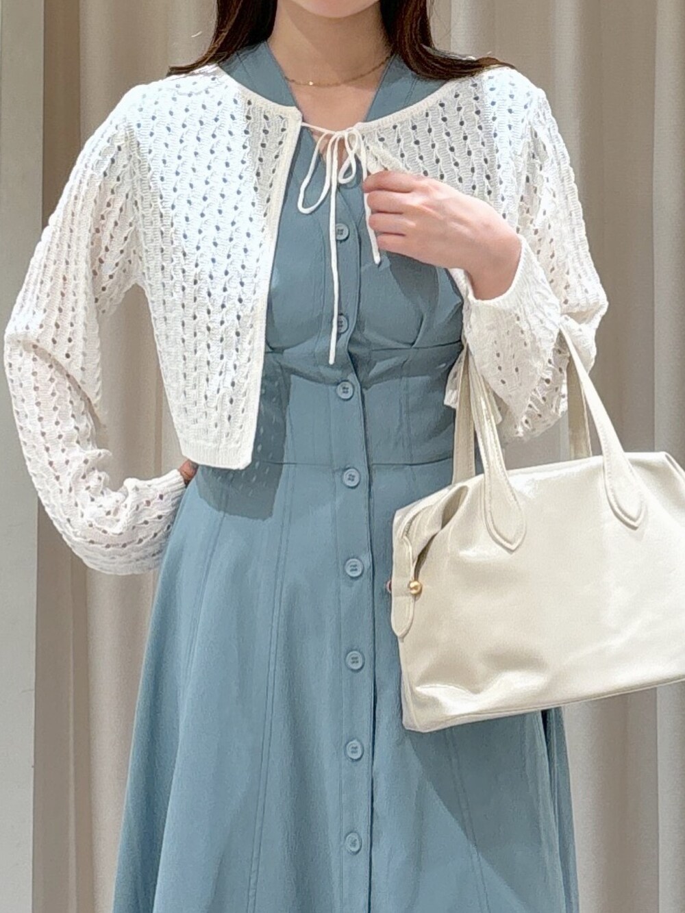 ブルー系のワンピース、ホワイト系のボストンバッグ、ブラウン系のサンダルを着用したレディースの夏コーディネートの4枚目の写真