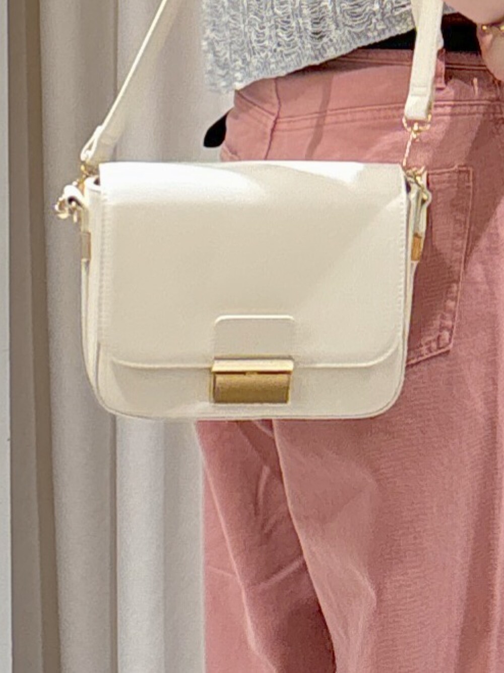 グレー系のニット/セーター、ブラック系のキャミソール、ピンク系のデニムパンツを着用したレディースの夏コーディネートの8枚目の写真