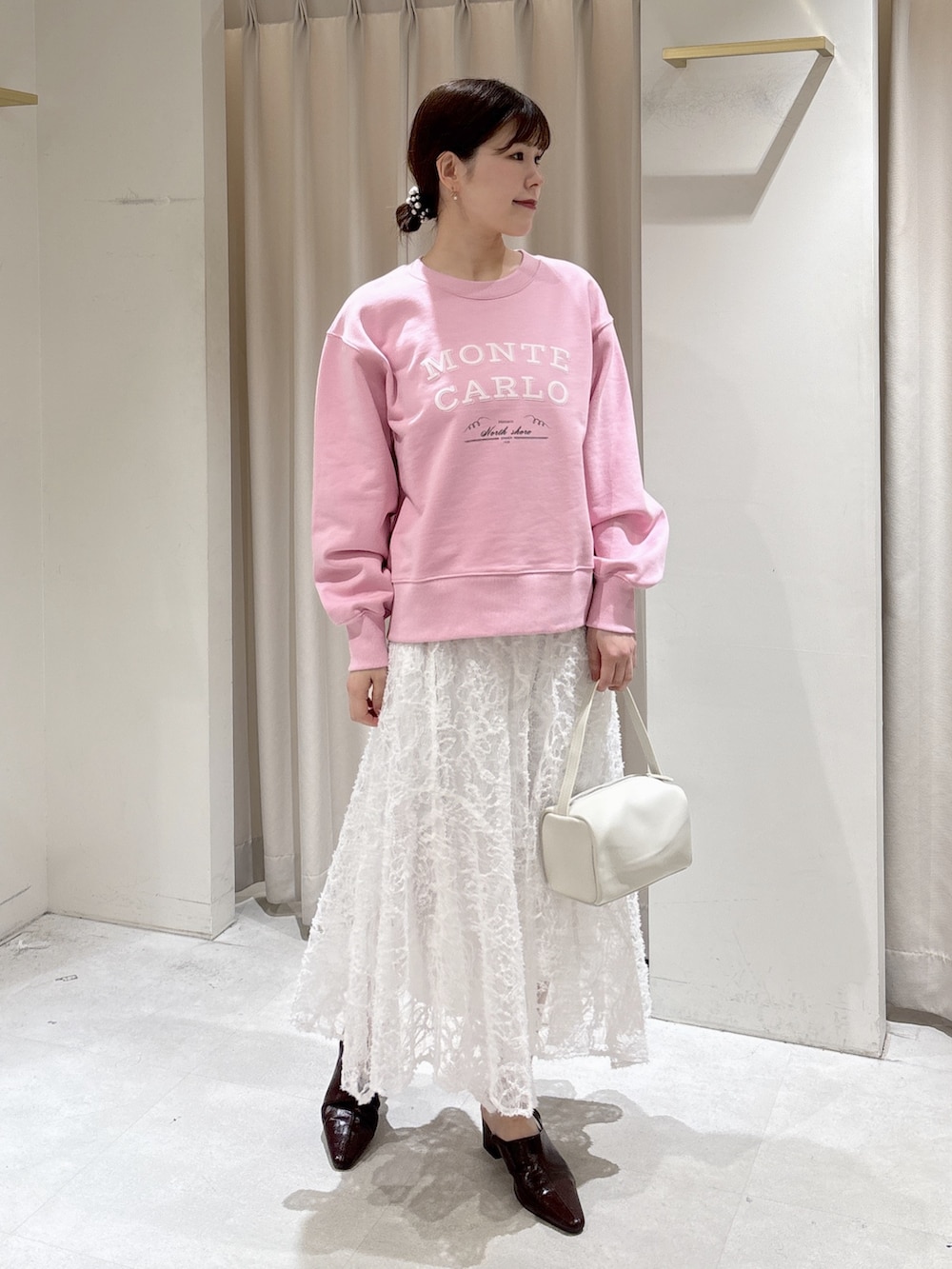 ピンク系のスウェット、ホワイト系のスカート、ブルー系のデニムパンツを着用したレディースの冬コーディネートの6枚目の写真