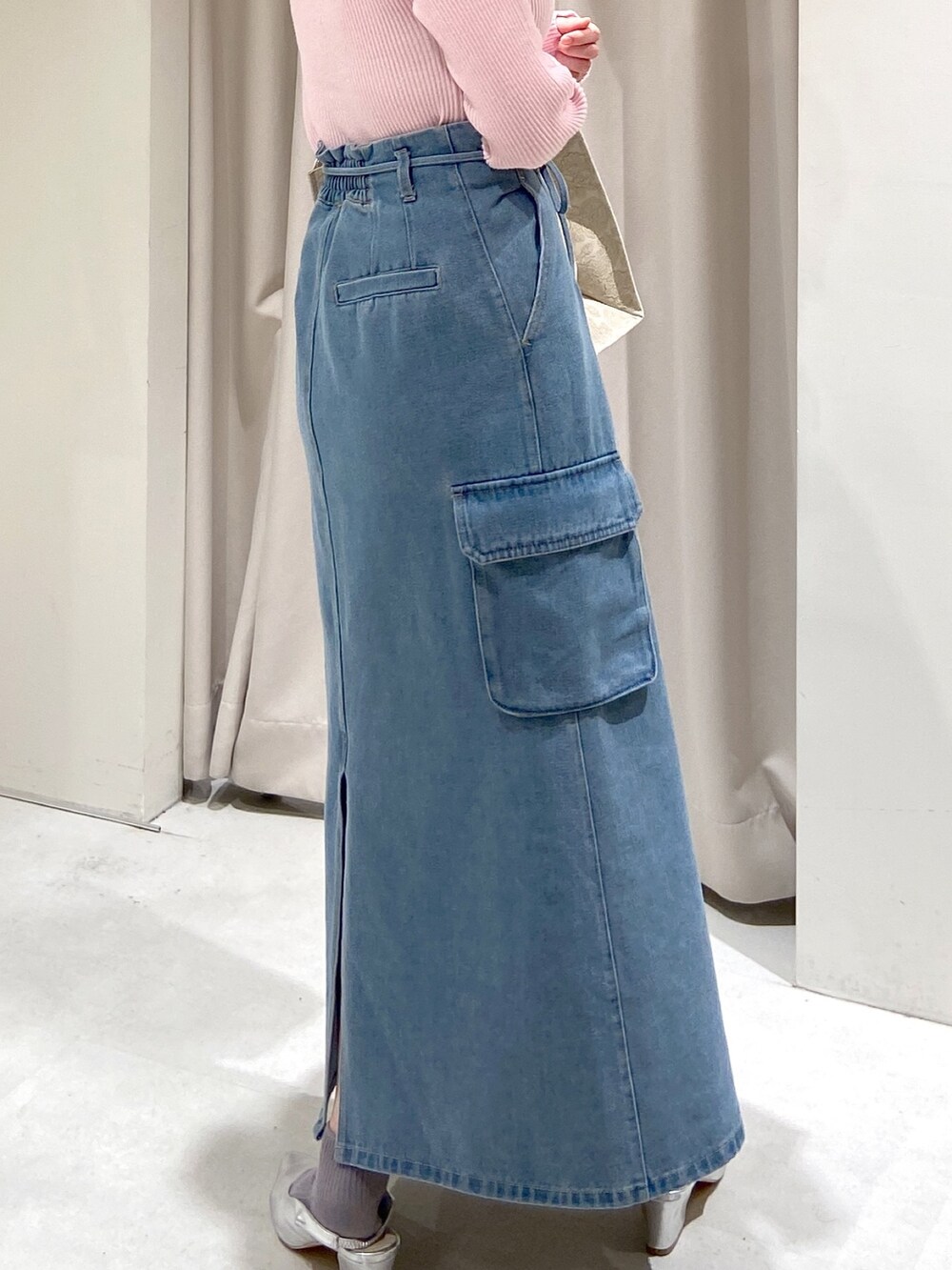 ブルー系のデニムスカート、ホワイト系のトートバッグ、シルバー系のパンプスを着用したレディースの冬コーディネートの3枚目の写真