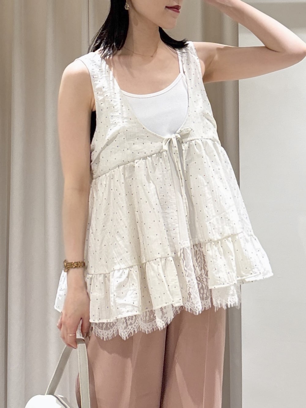 ホワイト系のハンドバッグ、ピンク系のスラックス、ブラック系のサンダルを着用したレディースの夏コーディネートの4枚目の写真