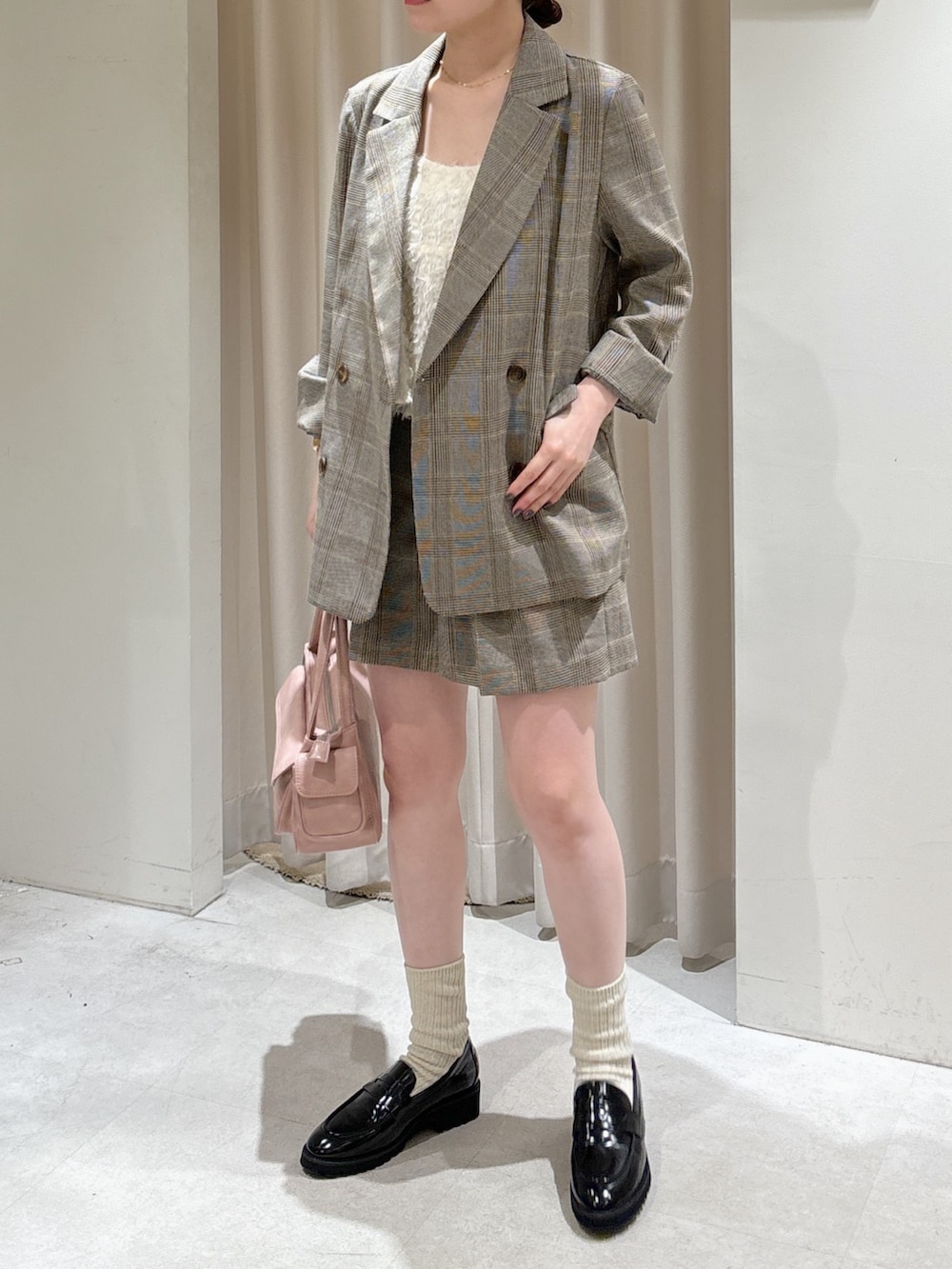 グレー系のテーラードジャケット、グレー系のその他パンツ、ピンク系のショルダーバッグを着用したレディースの春コーディネートの2枚目の写真